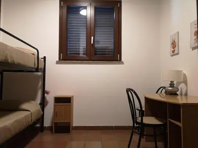 a room with a bed and a desk and a window at Villa Calcerame in Montelepre