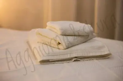 a pile of towels sitting on top of a bed at Agghiorna&skura house in Palermo