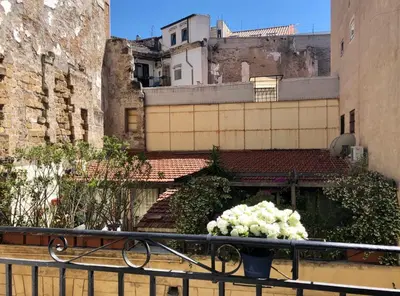 a bedroom with a bed and a tv and a window at Piazza Marina Open Space in Palermo