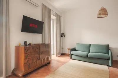 a living room with a blue couch and a television at Piazza Marina Open Space in Palermo