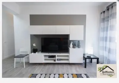 a white living room with a tv and a couch at Gelkamar Apartment in Santa Flavia
