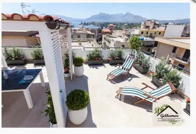 a patio with two chairs and a table on a balcony at Gelkamar Apartment in Santa Flavia