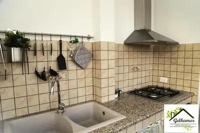 a kitchen with a sink and a stove at Gelkamar Apartment in Santa Flavia