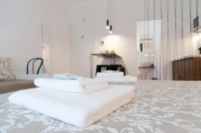 a room with a bed and a desk and a sink at Carrettieri54 - apartment historic center Palermo in Palermo