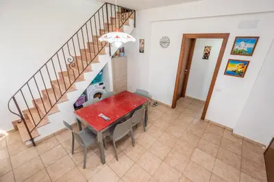 a kitchen and dining room with a table and stairs at Villa Pietro in Lascari