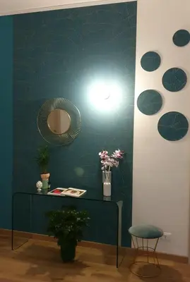 a room with a green wall with a table and a mirror at Civico 20 in Palermo