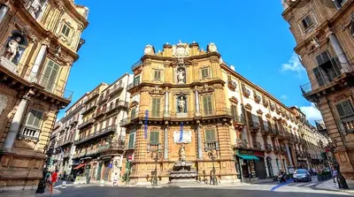 a tall building with a clock on the front of it at Civico 20 in Palermo