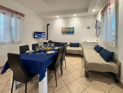 a dining room with a blue table and chairs at Case Vacanze Mare Nostrum - Villas in front of the Beach with Pool in Campofelice di Roccella