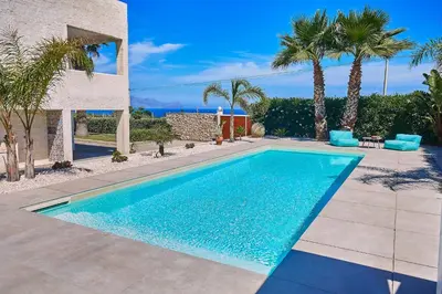a swimming pool with palm trees and a house at Villa Ciuridda in Alcamo
