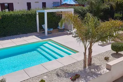 a swimming pool in a yard with a palm tree at Villa Ciuridda in Alcamo
