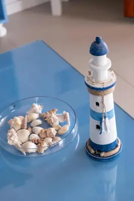 a model lighthouse and a bowl of shells on a table at il sogno di Saffo in Palermo