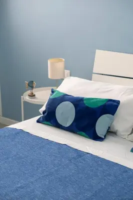 a blue and white bed with a blue pillow on it at il sogno di Saffo in Palermo