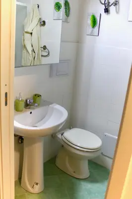 a bathroom with a white toilet and a sink at Nido Verde Locazione turistica Palermo in Palermo