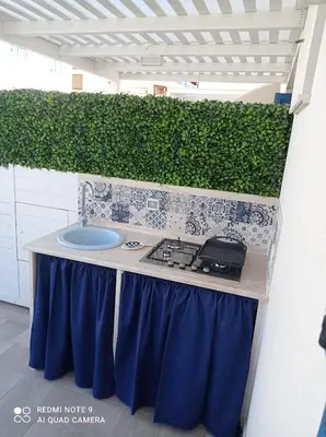 a outdoor kitchen with a counter with a sink at Coral Holiday San Vito Lo Capo in San Vito lo Capo
