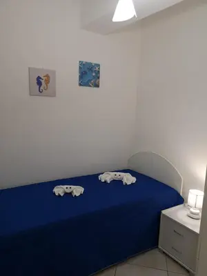a bedroom with a blue bed with two animal towels on it at Casetta 