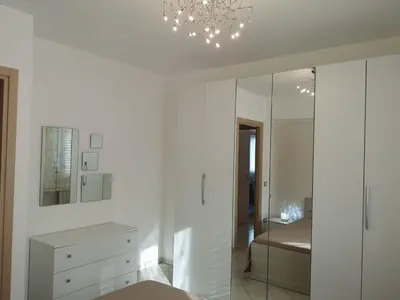 a white bedroom with a bed and a mirror at Casetta 
