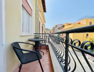 a balcony with chairs and a table on a building at Casa Kennedy in Capaci