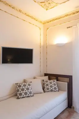 a living room with a couch and a tv on a ceiling at Appartamenti Porto Antico La Cala in Palermo