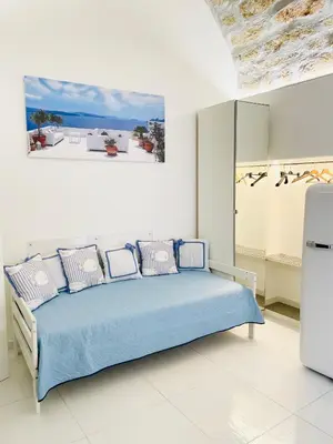 a white bedroom with a blue bed with pillows at BLU MARE suite privata & apartment in Terrasini