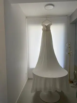a wedding dress hanging in a white room at Cocciu d’amuri in Terrasini