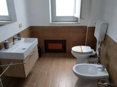 a bathroom with a toilet and a sink and a fire place at Olivuzza Serena in Palermo