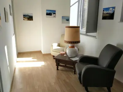 a living room with a chair and a lamp on a table at Olivuzza Serena in Palermo