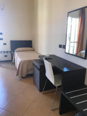 a bedroom with a desk and a bed with a mirror at Castellammare Smart Rooms in Castellammare del Golfo