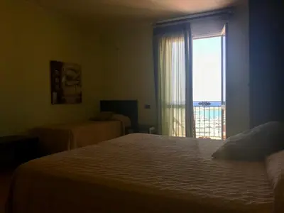 a bedroom with a bed and a window with a view at Castellammare Smart Rooms in Castellammare del Golfo