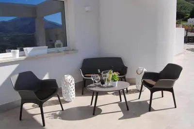 four chairs and a table on a patio at Villa Edori - Giardino degli Allori in Castellammare del Golfo