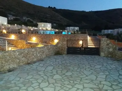 a stone building with a garage at night at Villa Edori - Giardino degli Allori in Castellammare del Golfo