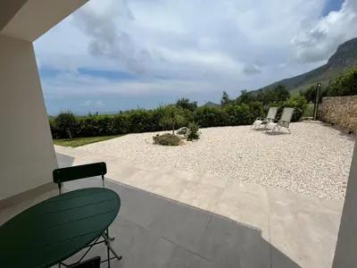 a patio with two chairs and a gravel yard at Villa Edori - Giardino degli Allori in Castellammare del Golfo