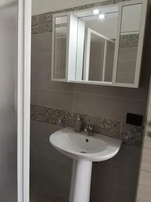 a bathroom with a white sink and a mirror at Appartamento a San Vito lo capo in San Vito lo Capo