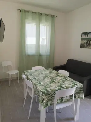 a living room with a table and chairs and a couch at Appartamento a San Vito lo capo in San Vito lo Capo