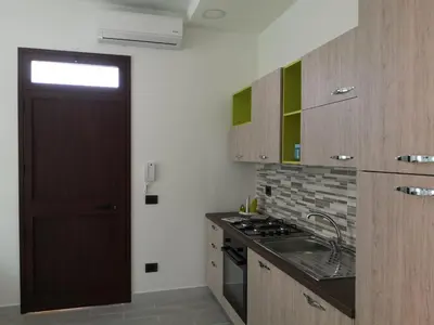 a kitchen with a door and a sink and a stove at Appartamento a San Vito lo capo in San Vito lo Capo