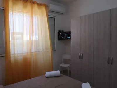 a bedroom with a bed and a curtain and a window at Appartamento a San Vito lo capo in San Vito lo Capo