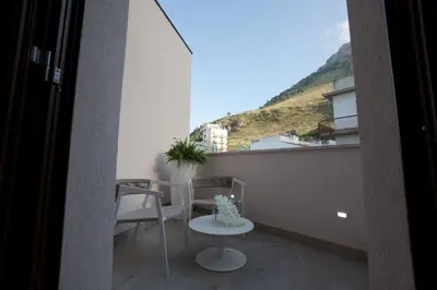 a balcony with a table and chairs and a view at Stabile HolidayHome in Castellammare del Golfo