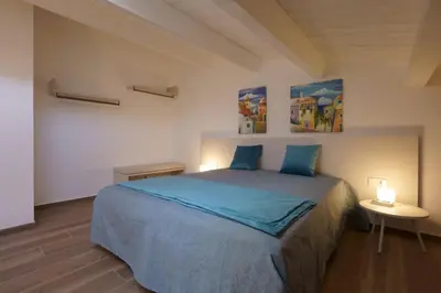 a bedroom with a bed and a table with two lamps at Stabile HolidayHome in Castellammare del Golfo