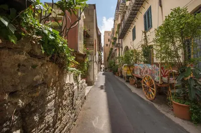 a street with a horse drawn carriage in an alley at Casa dell'Architetto alla Cattedrale by Wonderful Italy in Palermo