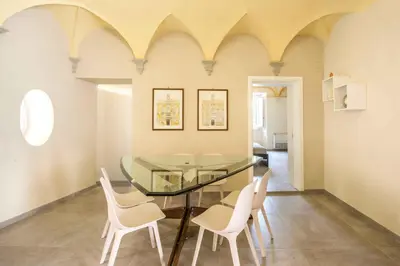 a dining room with a glass table and white chairs at Casa dell'Architetto alla Cattedrale by Wonderful Italy in Palermo