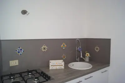 a kitchen counter with a sink and a stove at Gibilrossa BeeHill in Misilmeri