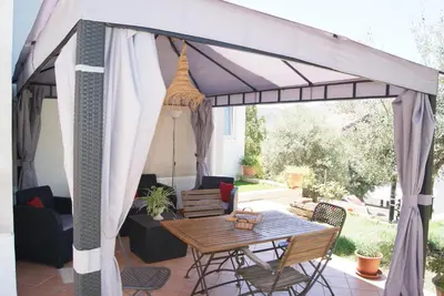 a pergola on a patio with a table and chairs at Gibilrossa BeeHill in Misilmeri