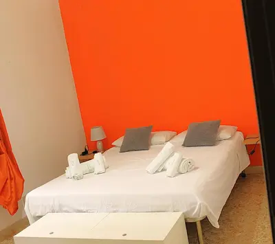 a bedroom with a bed with an orange wall at Casa gianflò in Palermo