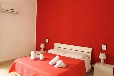 a red bedroom with a bed with towels on it at Casa gianflò in Palermo