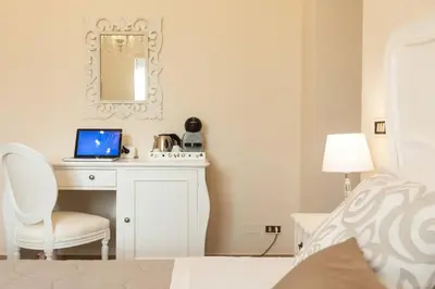 a bedroom with a desk with a laptop on it at Camera Vento Porto Antico La Cala in Palermo