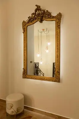 a mirror on a wall with a stool in front of it at Camera Vento Porto Antico La Cala in Palermo