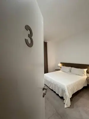 a bedroom with a bed with a number three on the wall at Palermo Inn in Palermo