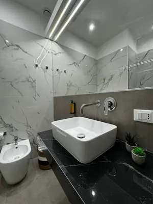 a bathroom with a large white sink and a toilet at Palermo Inn in Palermo