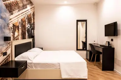 a bedroom with a bed and a desk and a mirror at Villena Plaza by Wonderful Italy in Palermo