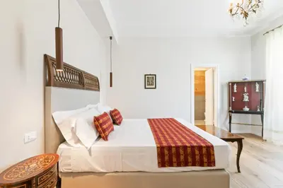 a white bedroom with a bed and a table at GuestHost - NotHotel Palermo Luxury Guest House in Palermo