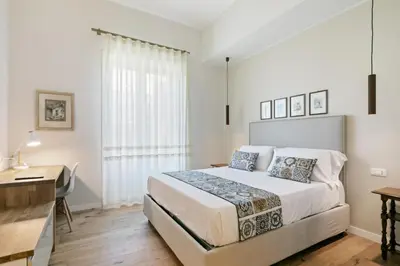 a bedroom with a bed and a desk and a window at GuestHost - NotHotel Palermo Luxury Guest House in Palermo